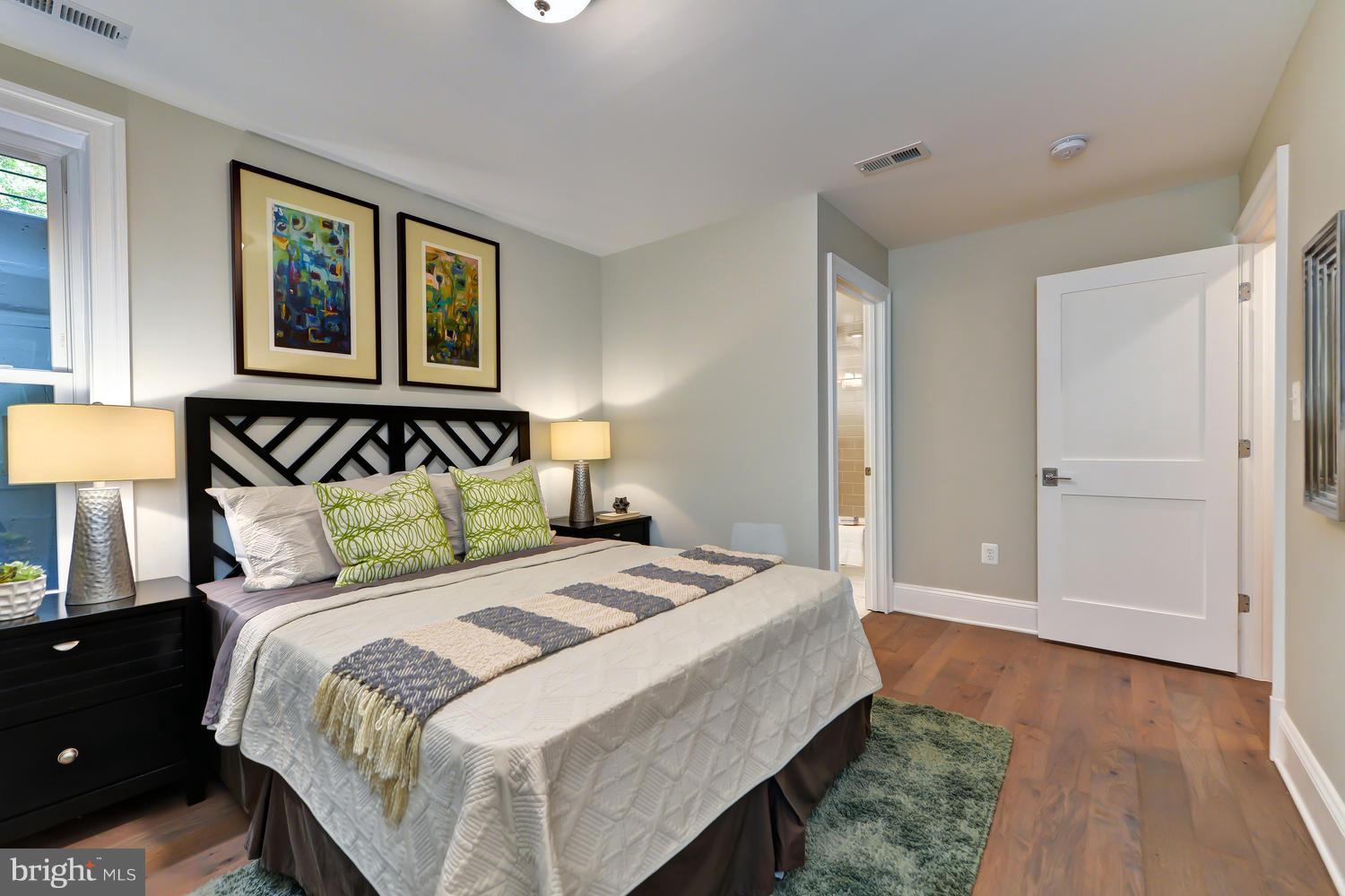 3921 Fulton Street Northwest, Unit 1 Washington, DC 20007 - Photo 12 of 25 a bedroom with a large bed and a painting on the wall