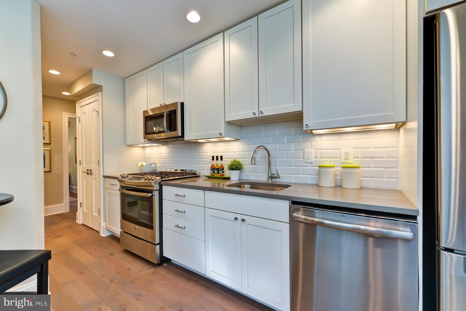 3921 Fulton Street Northwest, Unit 1 Washington, DC 20007 - Photo 5 of 25 a kitchen with stainless steel appliances granite countertop a sink a stove and a refrigerator