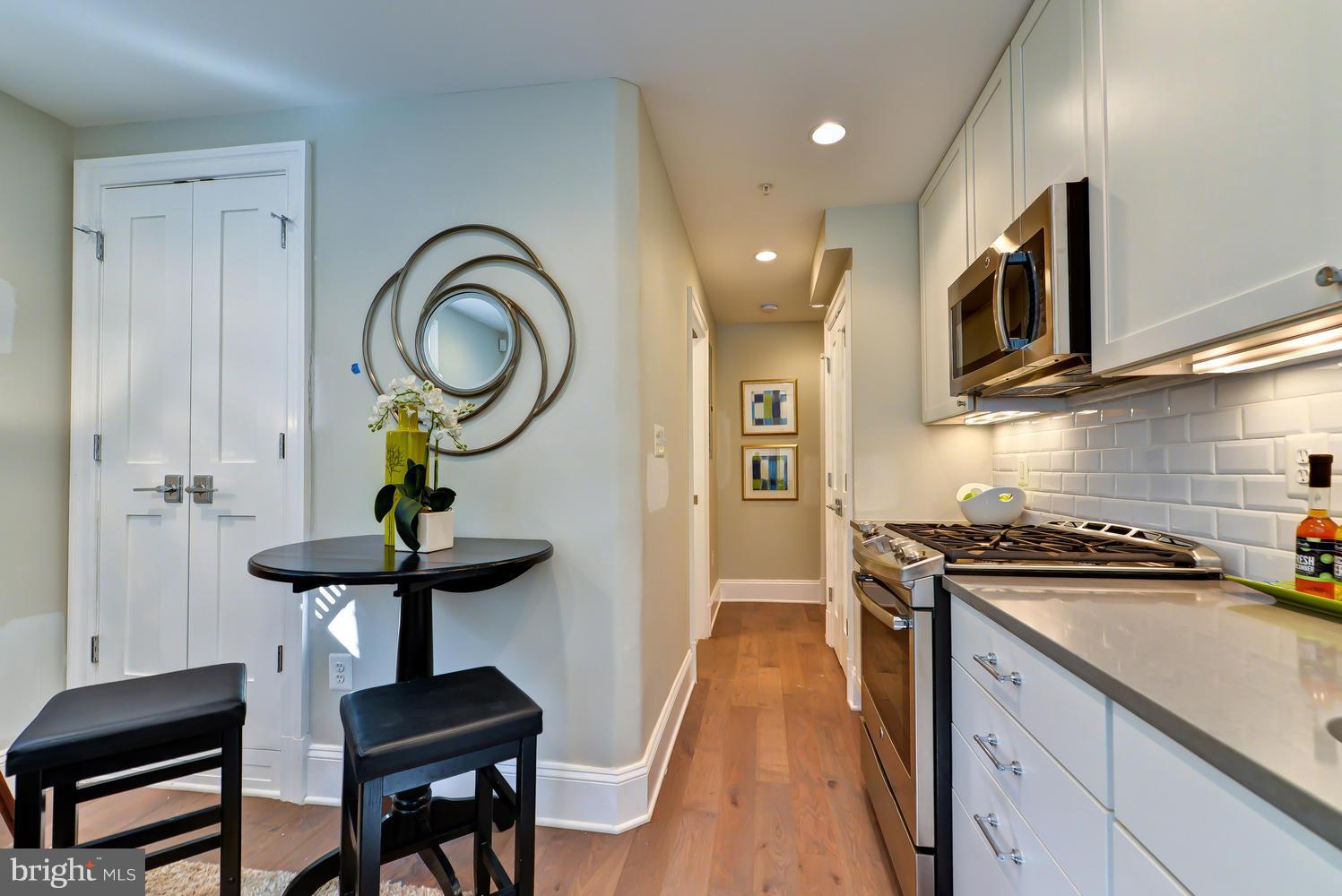 3921 Fulton Street Northwest, Unit 1 Washington, DC 20007 - Photo 7 of 25 a kitchen with a sink stainless steel appliances and wooden floor