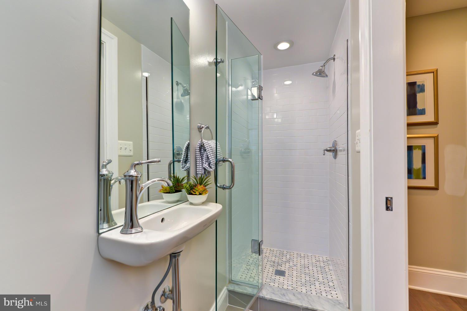 3921 Fulton Street Northwest, Unit 1 Washington, DC 20007 - Photo 10 of 25 a bathroom with a sink a mirror and a shower