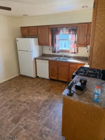 a kitchen with sink a refrigerator and window