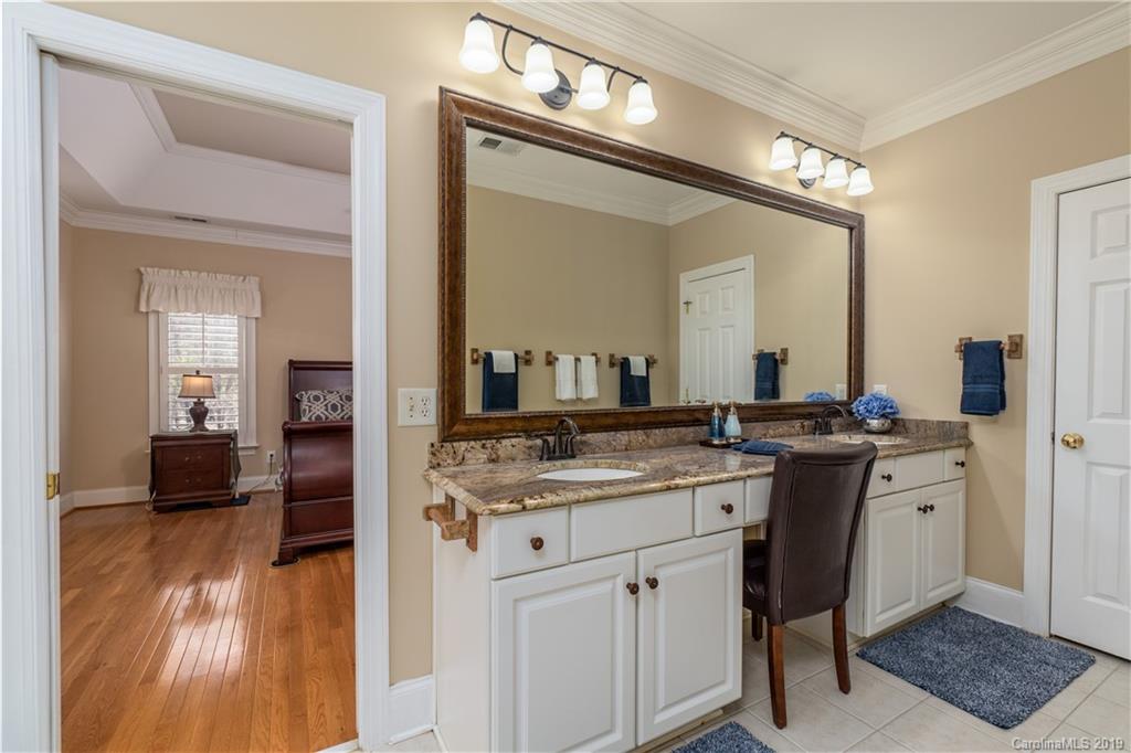 3116 Rhett Butler Place Charlotte, NC 28270 - Photo 9 of 18 a bathroom with a granite countertop sink a mirror and a vanity