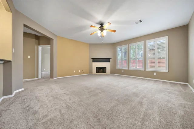 a view of an empty room with a window and hardwood floor