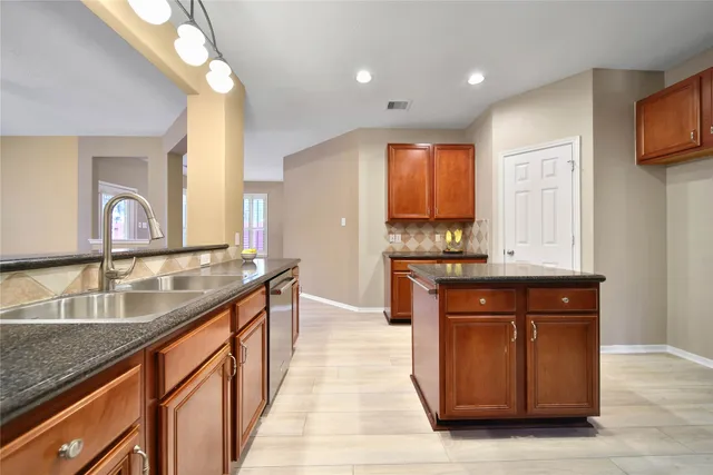 a kitchen with stainless steel appliances granite countertop a sink a stove and a refrigerator