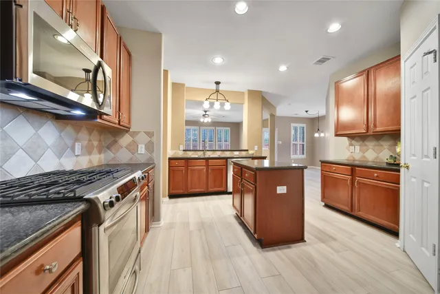 an empty room with windows and ceiling fan