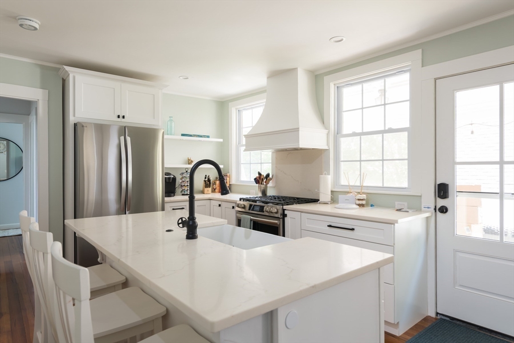 16 Jefferson Shores Road Wareham, MA 02532 - Photo 23 of 37 a kitchen with stainless steel appliances a white refrigerator a sink a stove and white cabinets with wooden floor