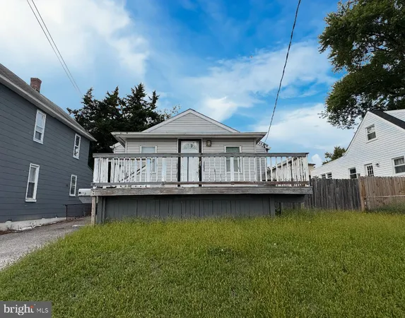 a wooden deck that has a table and chairs with wooden fence
