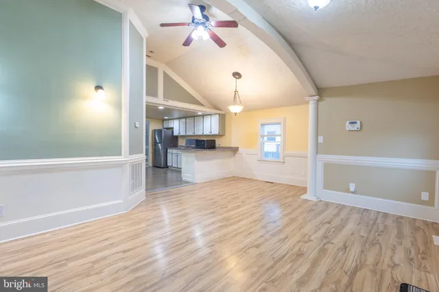 a view of a kitchen with wooden floor and a ceiling fan