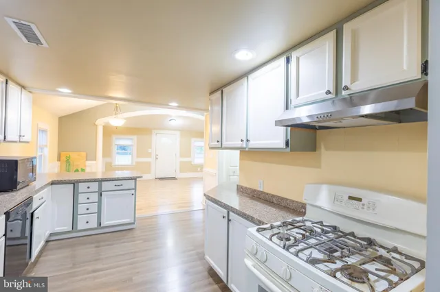 a kitchen with stainless steel appliances a refrigerator sink and microwave