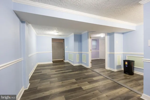 a view of empty room with wooden floor and fireplace