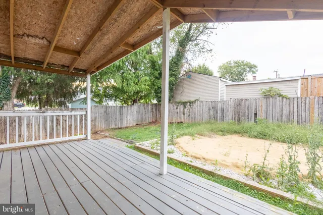 a view of backyard with wooden floor and fence