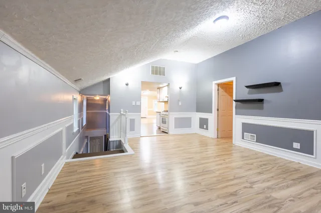 a view of empty room with wooden floor