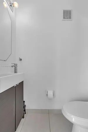 a bathroom with a sink mirror and toilet