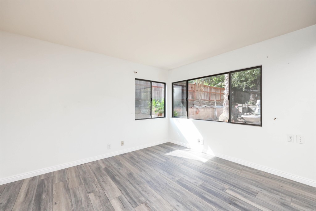 2513 Sarbonne Drive Oceanside, CA 92054 - Photo 22 of 55 a view of an empty room with wooden floor and a window