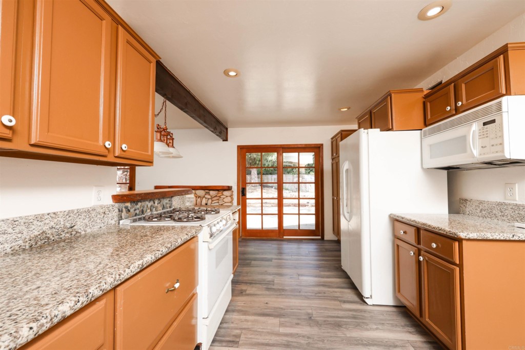 2513 Sarbonne Drive Oceanside, CA 92054 - Photo 31 of 55 a kitchen with stainless steel appliances granite countertop a sink stove and cabinets