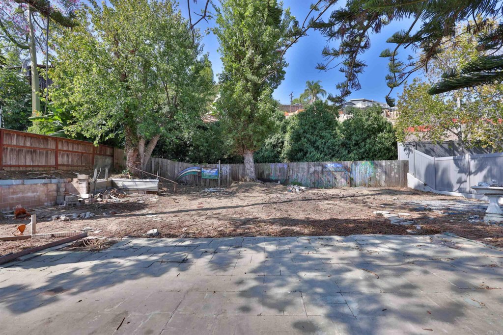 2513 Sarbonne Drive Oceanside, CA 92054 - Photo 40 of 55 a view of a backyard with large trees and wooden fence