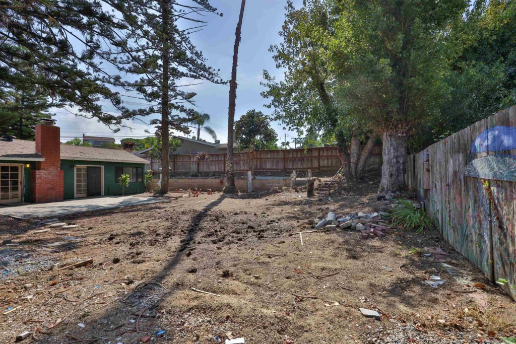 2513 Sarbonne Drive Oceanside, CA 92054 - Photo 45 of 55 a view of a backyard with large trees and wooden fence