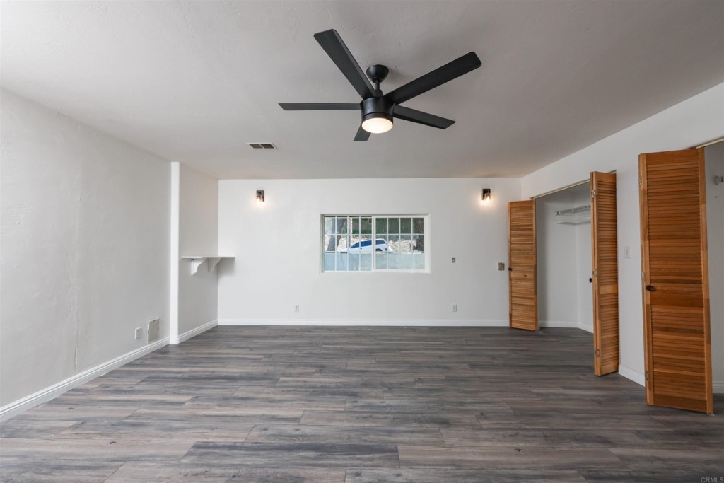 2513 Sarbonne Drive Oceanside, CA 92054 - Photo 9 of 55 a view of an empty room with wooden floor and a ceiling fan