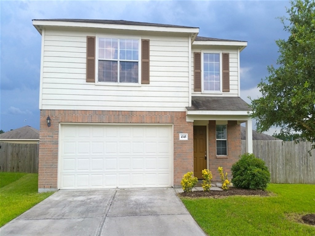 4345 Medina River Loop Spring, TX 77386 - Photo 1 of 14 a front view of a house with a yard and a garage
