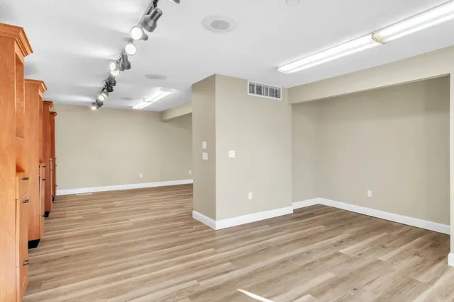 a view of a room with wooden floor and ceiling fan