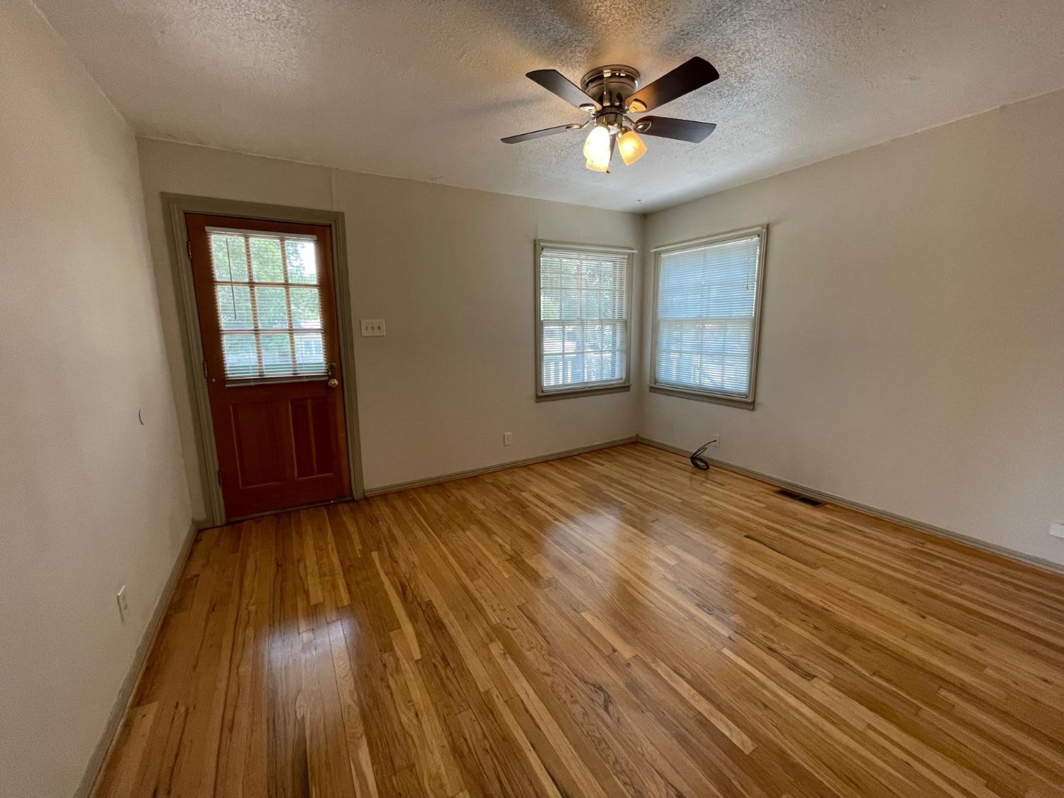 3018 29th Street Lubbock, TX 79410 - Photo 4 of 14 wooden floor in an empty room with a window