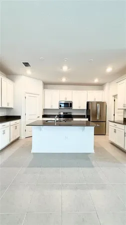 a large white kitchen with stainless steel appliances