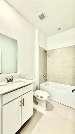 a bathroom with a double vanity sink toilet mirror and bathtub