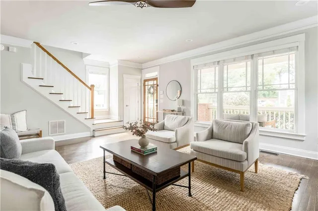 a living room with wooden floor and large window
