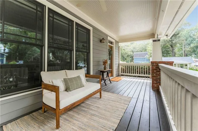 a balcony with wooden floor table and chairs