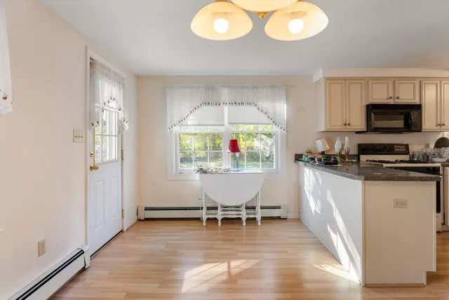 a dining room with wooden floor and a chandelier