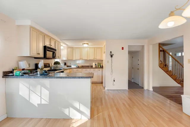 a kitchen with granite countertop a refrigerator stove top oven and sink