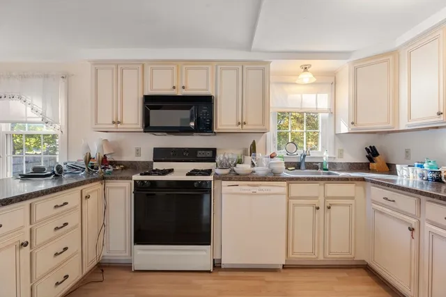 a kitchen with cabinets stainless steel appliances a sink and a window