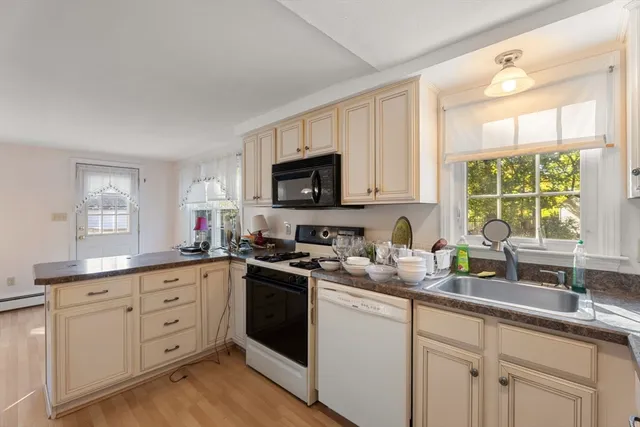 a kitchen with appliances a sink and a window