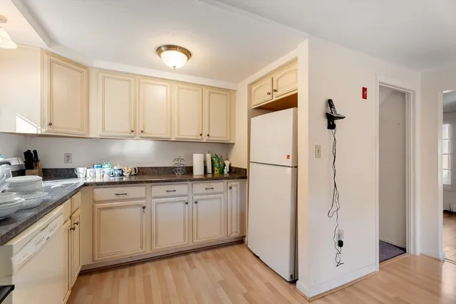 a kitchen with stainless steel appliances granite countertop a refrigerator sink and white cabinets