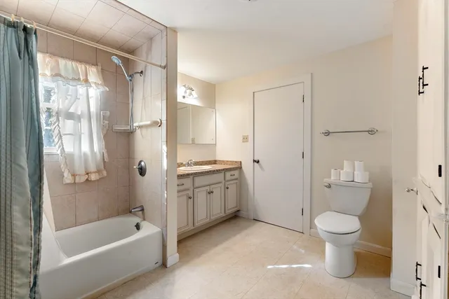 a bathroom with a granite countertop toilet a sink and a large mirror