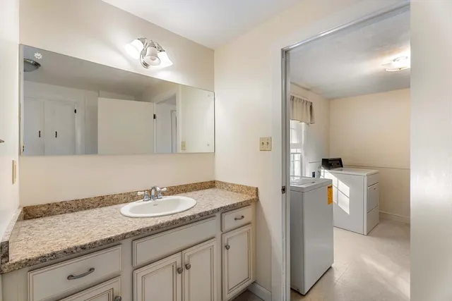 a bathroom with a granite countertop sink and a mirror