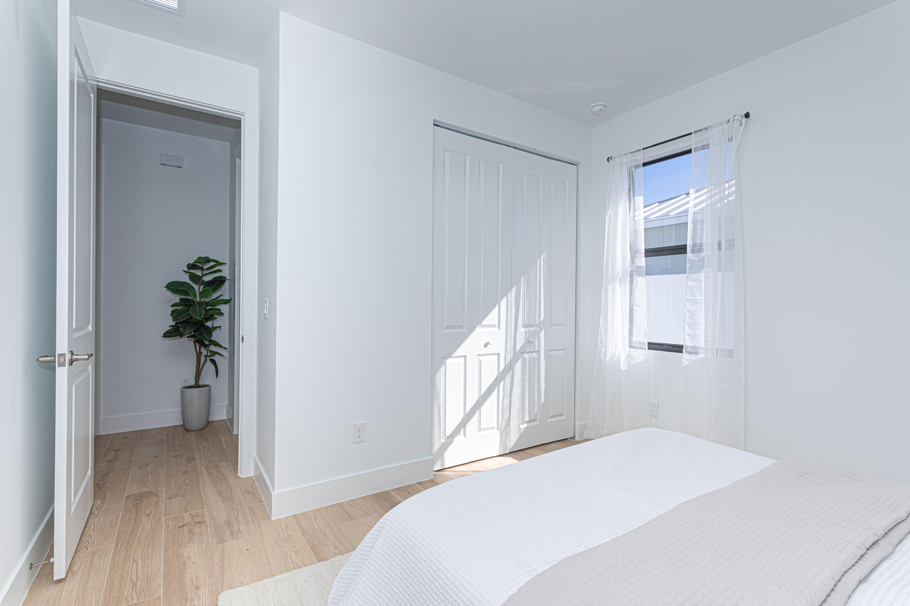 314 4th Street Jupiter, FL 33458 - Photo 25 of 55 a bedroom with a bed and a potted plant