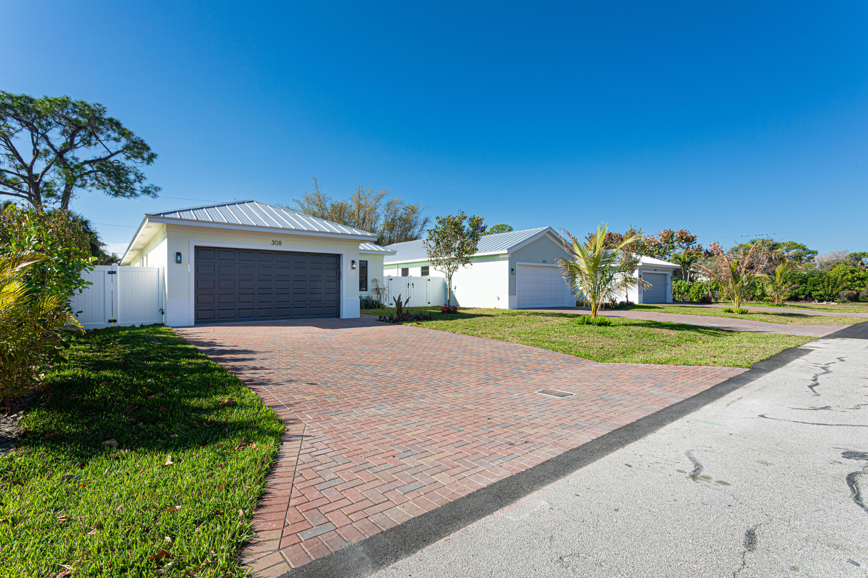314 4th Street Jupiter, FL 33458 - Photo 5 of 55 a front view of a house with a yard and garage