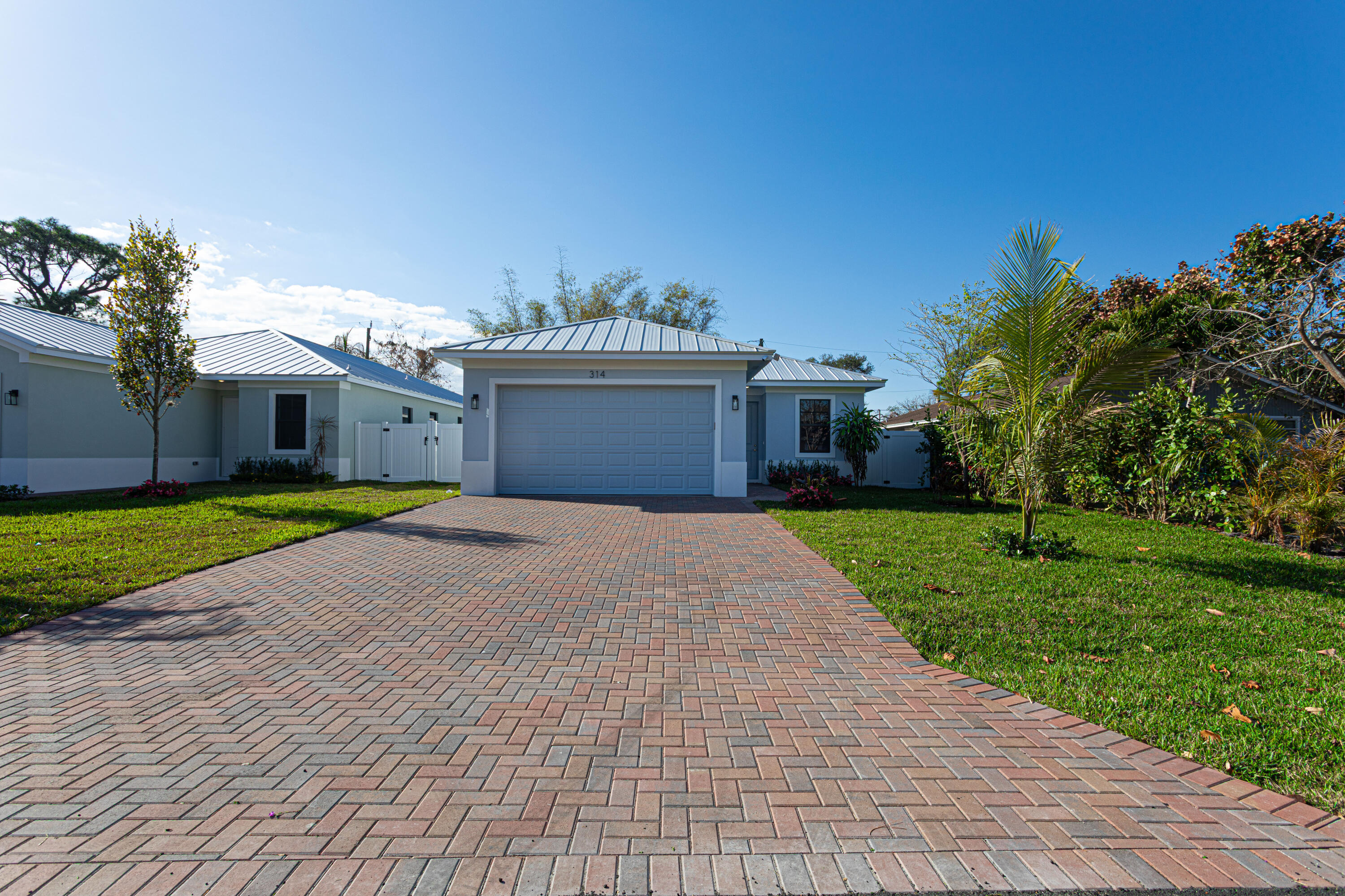 314 4th Street Jupiter, FL 33458 - Photo 6 of 55 a front view of a house with a yard and garage