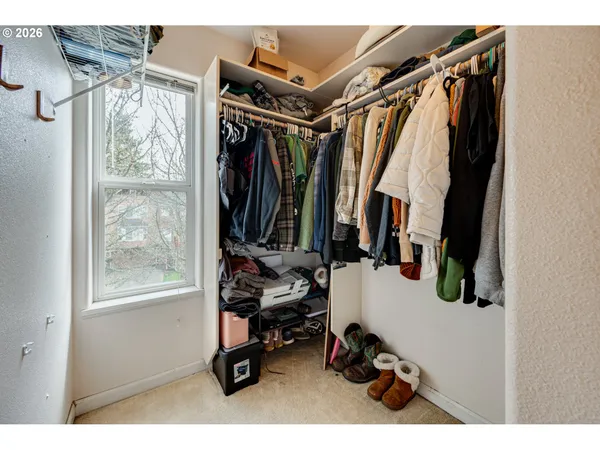 a view of walk in closet with clothes and shoes