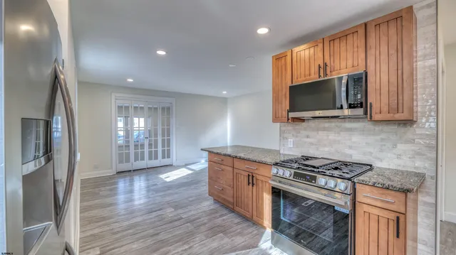 a large kitchen with a refrigerator a stove top oven and a sink