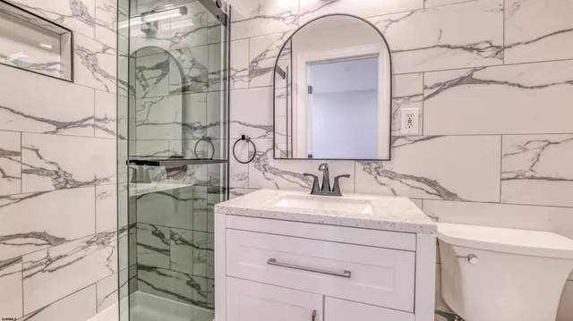 a bathroom with a sink and mirror with bathtub