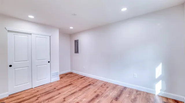 an empty room with wooden floor and windows