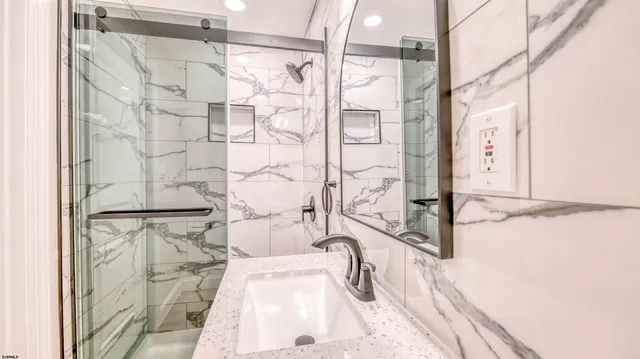 a bathroom with a granite countertop sink toilet and shower