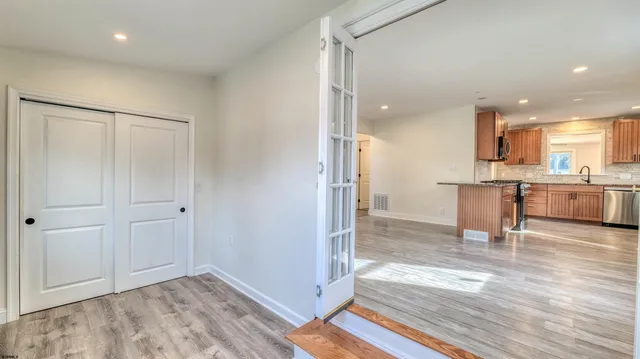 a view of kitchen with stainless steel appliances granite countertop a stove top oven a sink and a refrigerator
