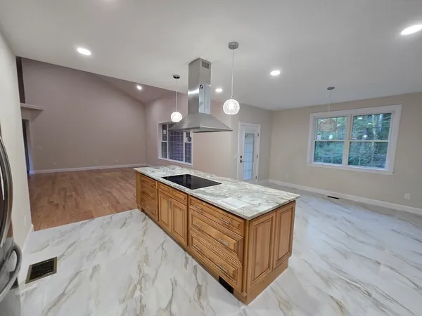 a kitchen with a stove and a wooden floor