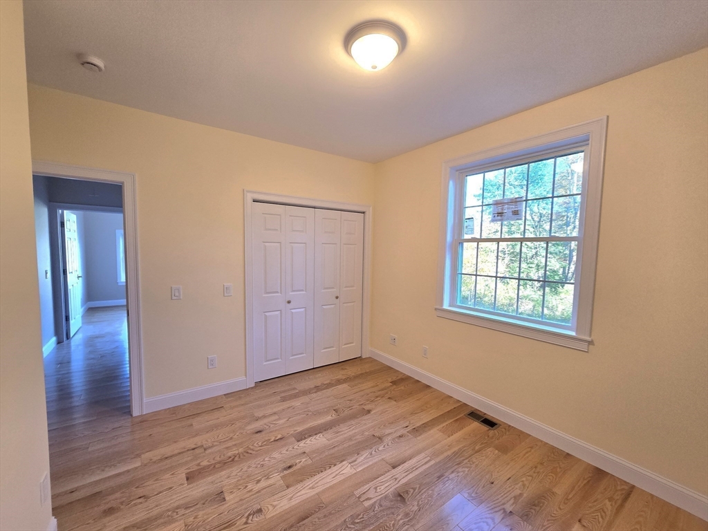73 Dudley Hill Road Dudley, MA 01571 - Photo 20 of 33 a view of an empty room with wooden floor and a window