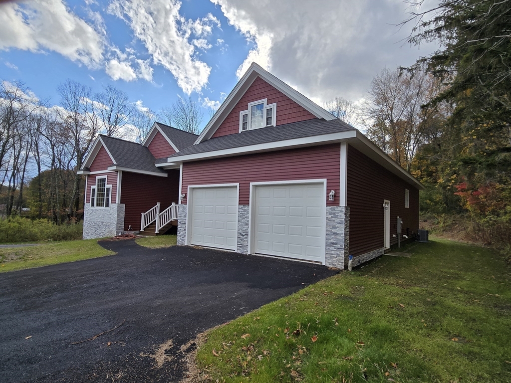 73 Dudley Hill Road Dudley, MA 01571 - Photo 4 of 33 a front view of a house with a yard and garage