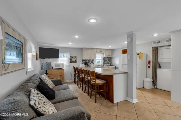 a living room with furniture a flat screen tv and kitchen view