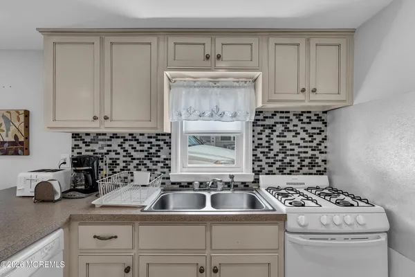 a kitchen with a stove a sink and cabinets
